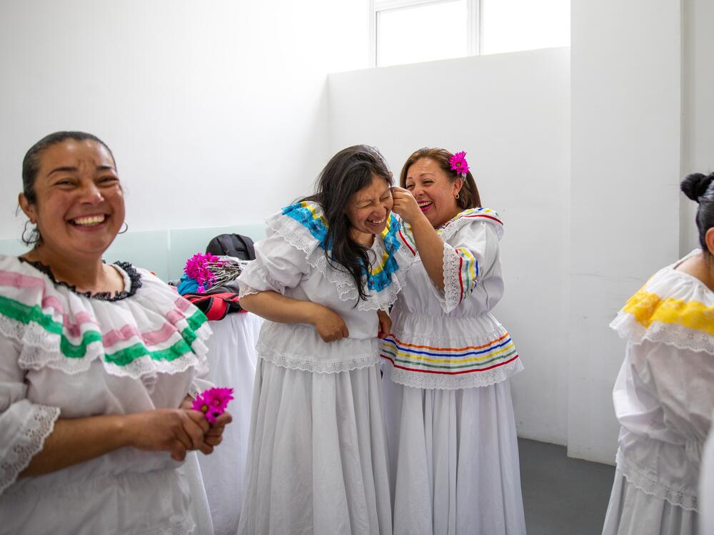 Ruth Infante (second from left), a single mother of three, and her classmates donned traditional flowing dresses for their <em>Cumbia</em> dance performance at a center in Bogotá, Colombia, that provides happy respite for family caregivers.