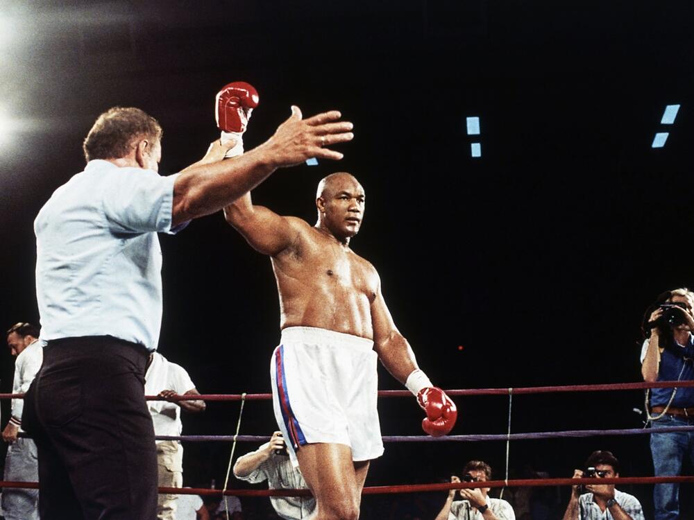 Former heavyweight champion George Foreman has hit glove lifted into the air after referee Al Munoz gave Foreman the victory in his heavyweight fight against Bert Cooper in Phoenix, on June 2, 1989.