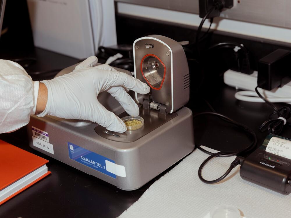 A research scientist measures water activity in a flower sample at a Department of Cannabis Control lab.