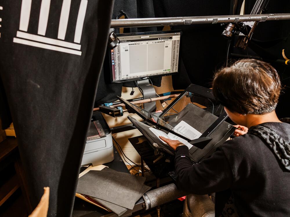 An employee at Internet Archive office digitizes a book.
