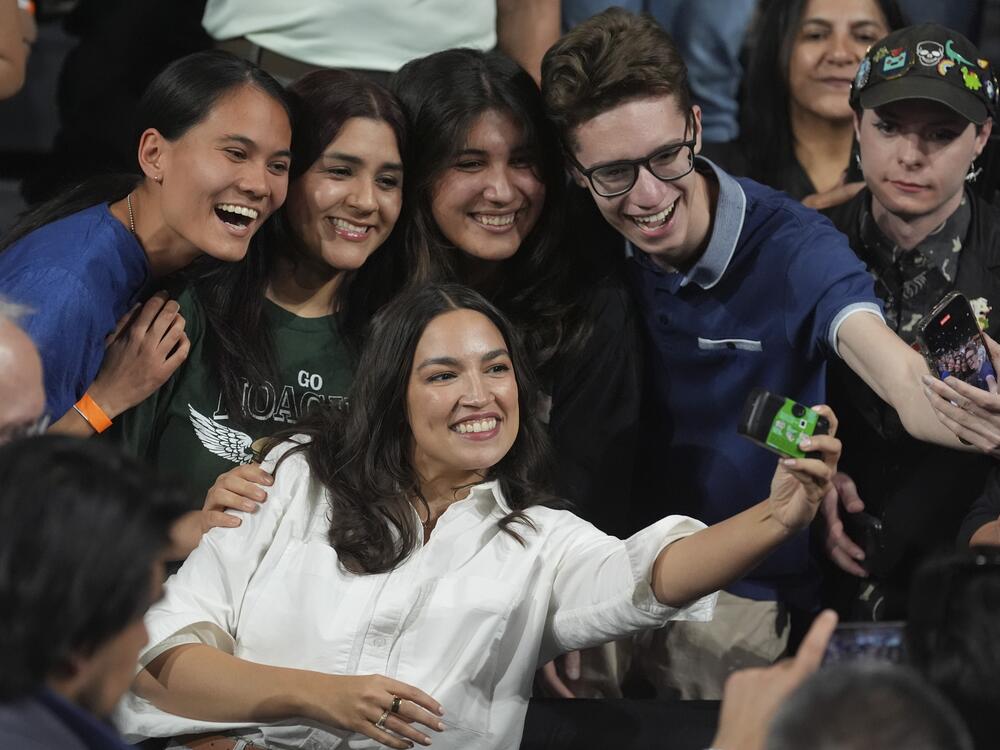 Rep. Alexandria Ocasio-Cortez, D-N.Y., right, takes a photo with supporters after speaking during a 