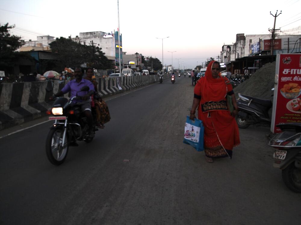 A woman walks at dusk in the district of Sriperumbudur in the southern Indian state of Tamil Naidu.