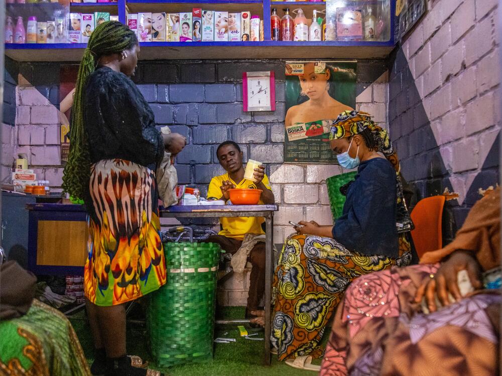 An assistant at a shop in Kano, Nigeria, mixes a concoction of creams and gels and cracks a few capsules to add in, creating a skin bleaching product for the waiting customers.