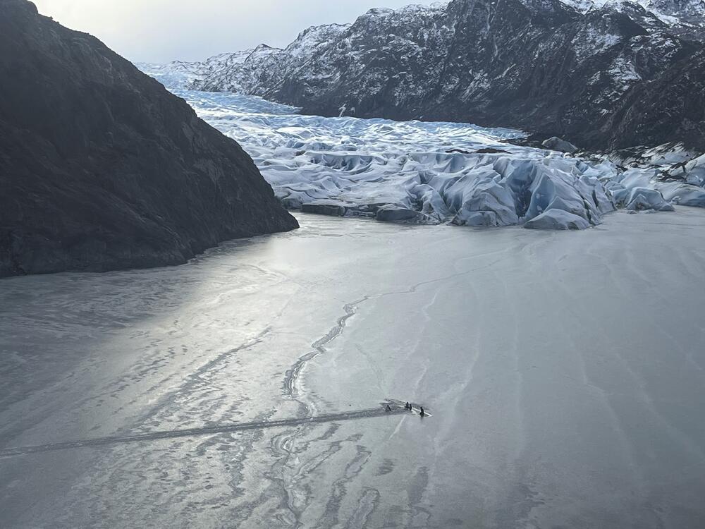 This photo provided by the Alaska National Guard shows an airplane partially submerged into the ice of Tustumena Lake at the toe of a glacier on Monday, March 24, 2025, near Soldotna, Alaska. (Alaska National Guard via AP)