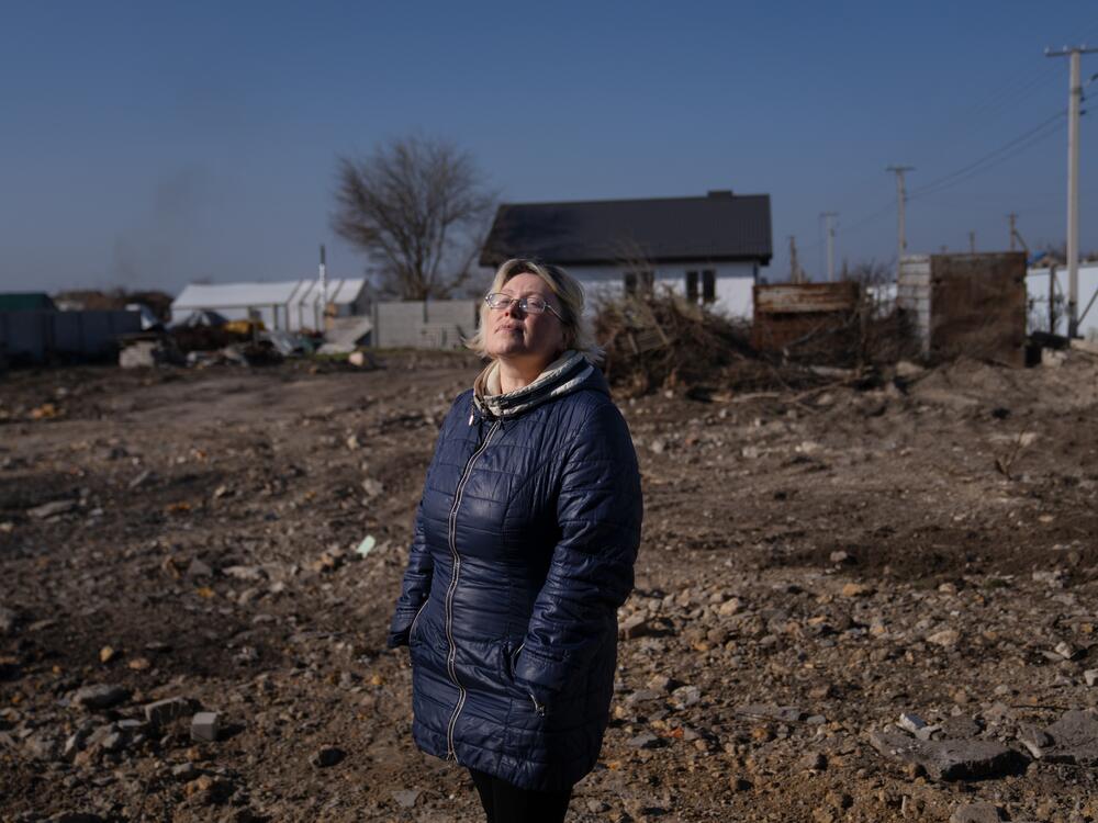 Larisa Prytsyk stands on the lot where the home she shared with her aging mother once stood. The remains have been cleared in preparation for a new house to be built. Mother and daughter returned to their village last November, more than two years after they'd evacuated. By then Russian forces had been pushed back for some time — but front line activity can still be heard less than 30 miles away.