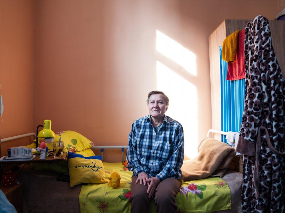 Halyna Zayceva sits on her bed at the ARTAK shelter, where she's been staying for the last six months since she was evacuated from Novohrodivka.