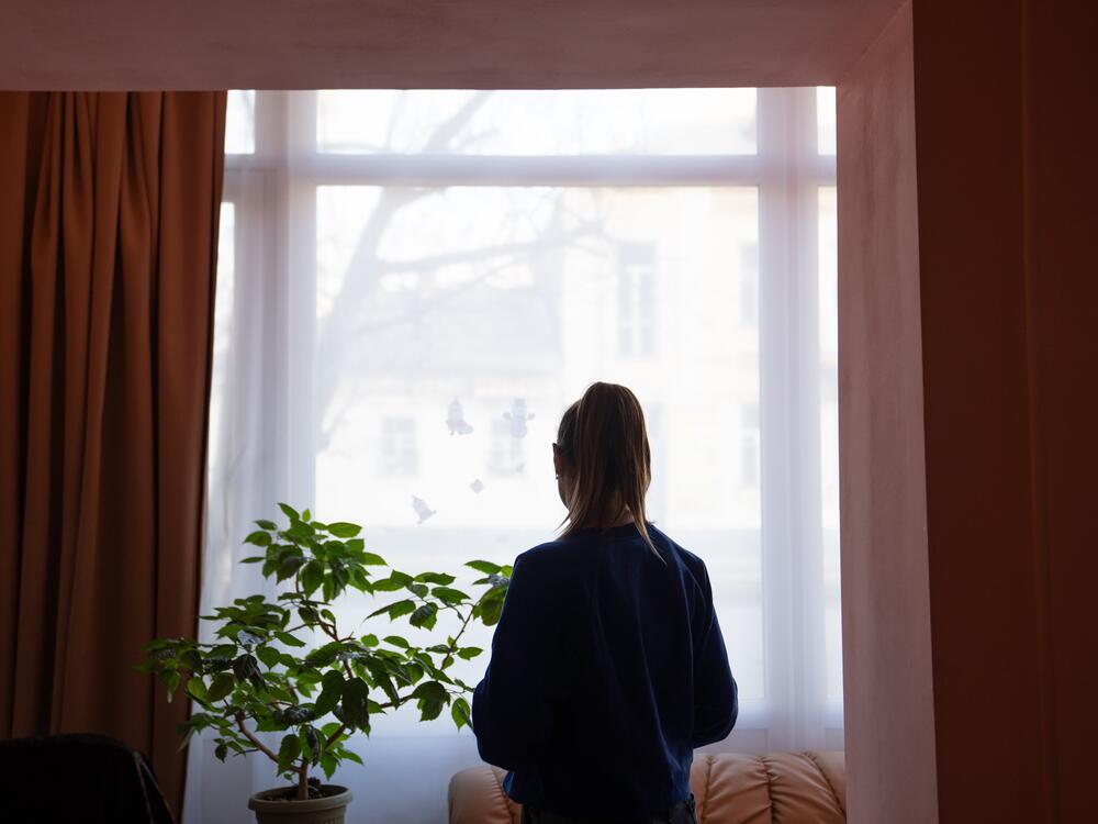 Anastasia stands in the dining room at ARTAK, the shelter where she helps others who have been displaced by the war. With her family home only four hours' drive away, she holds on to the idea that she could return one day. 