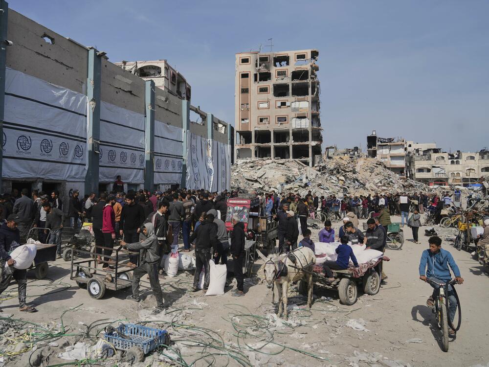Palestinians receive bags of flour and other humanitarian aid distributed by UNRWA, the U.N. agency helping Palestinian refugees, in Jabaliya, Gaza Strip, on Tuesday.
