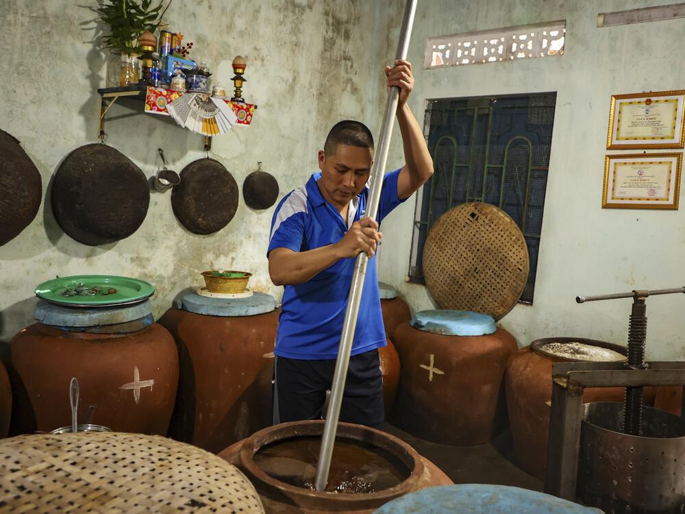 Phan Cong Quang makes fish sauce in his home in Nam O fishing village on March 4.