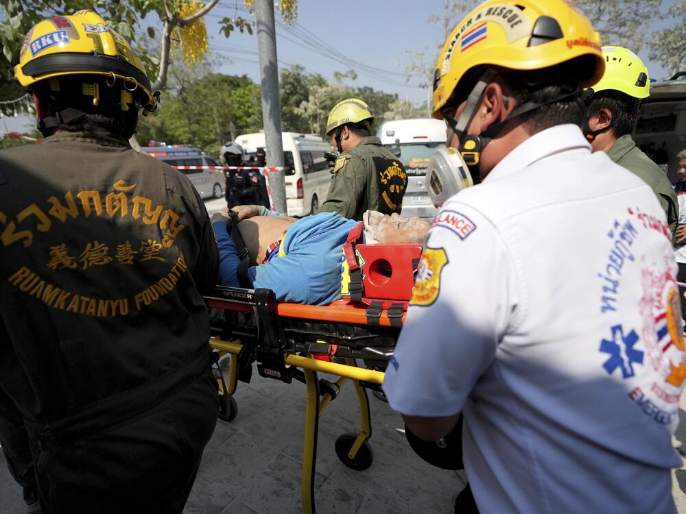 Rescuers carry an injured from the site of a high-rise building under construction that collapsed after a 7.7 magnitude earthquake in Bangkok, Thailand on Friday.