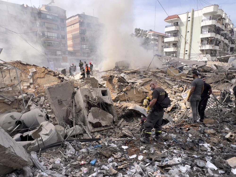 Firemen inspect the area after an Israeli army strike in the suburb of Dahiyeh, Lebanon, Friday.
