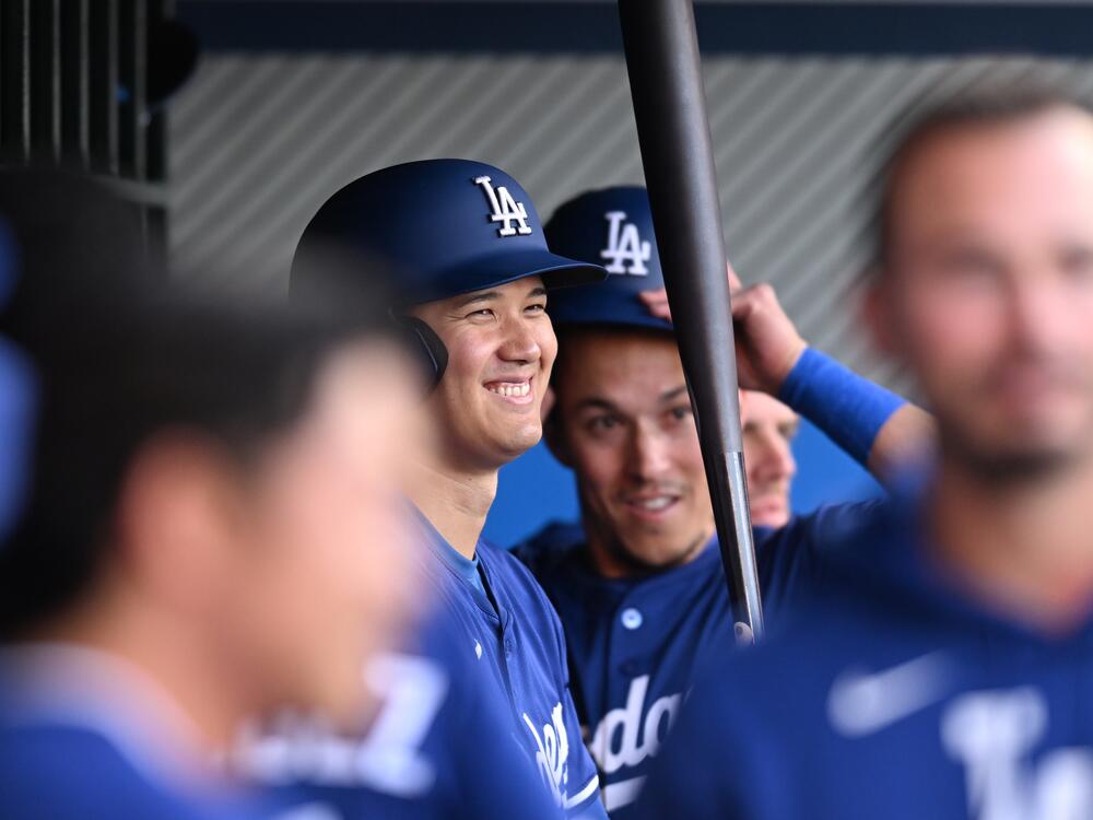 Shohei Ohtani, center, smiles before he and his Los Angeles Dodgers teammates play the Los Angeles Angels during a spring training game on March 24, 2025, in Anaheim, California.