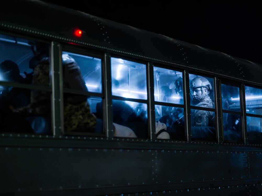 A member of the Salvadoran army stands guard on a bus with inmates at CECOT on March 16 in Tecoluca, El Salvador.