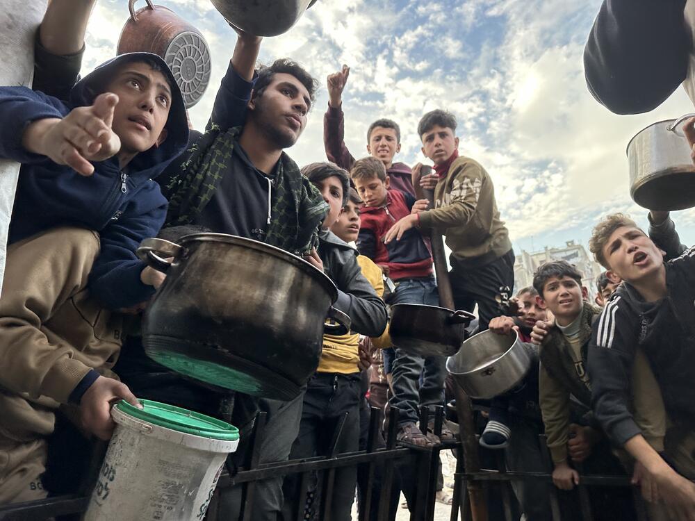 Palestinians wait in a food line with empty pots in Gaza City, Gaza on March 9, 2025.