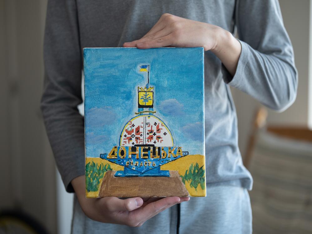 Andrii Koshun, 14, displays his painting honoring the city of Donetsk and the Ukrainian military at an apartment he shares with his mother and younger brother in Edina, MN, March 8, 2025.