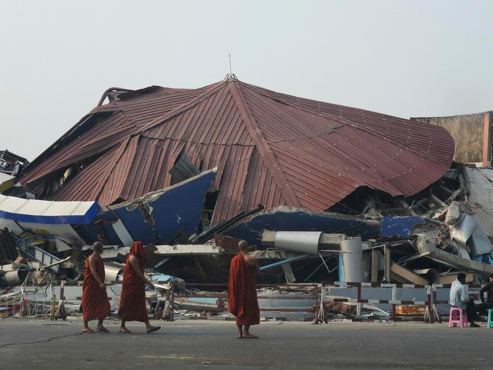 Buddhist monks walk past a collapsed building after a powerful earthquake in Naypyitaw, Myanmar, on Saturday.
