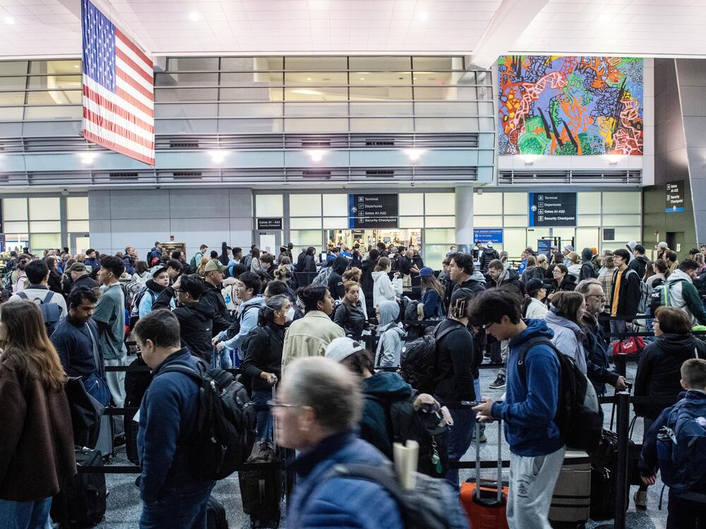 Travelers wait in the security line at Boston Logan International Airport in Boston on Dec. 21, 2023.