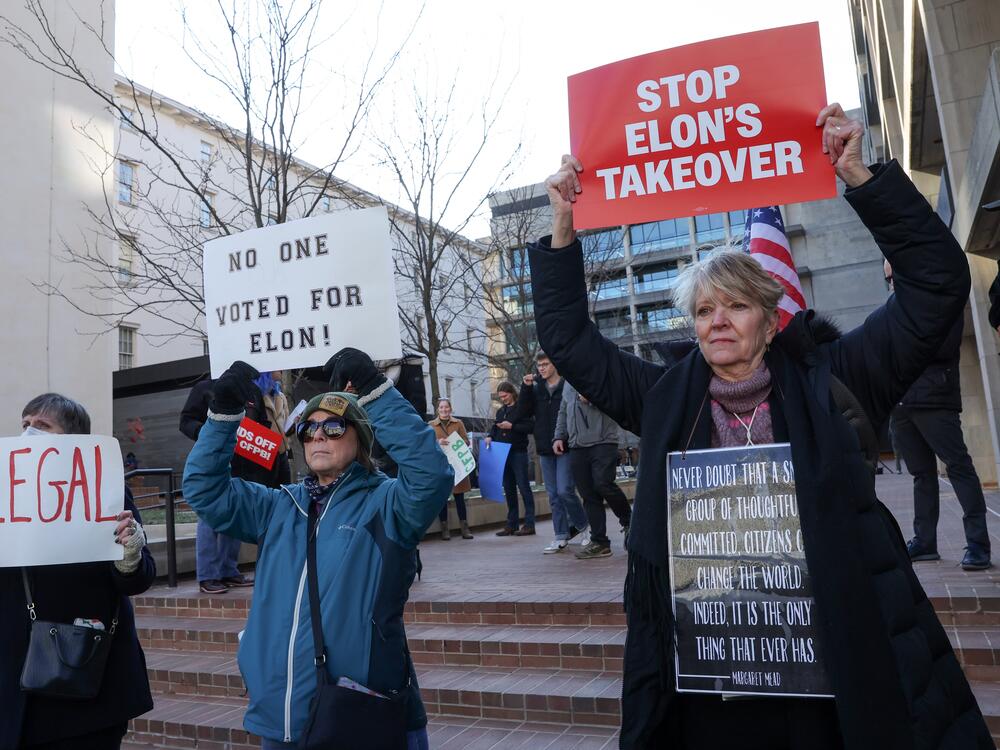 Demonstrators raise signs at a rally to protest the closing of the Consumer Financial Protection Bureau last month in Washington, D.C.