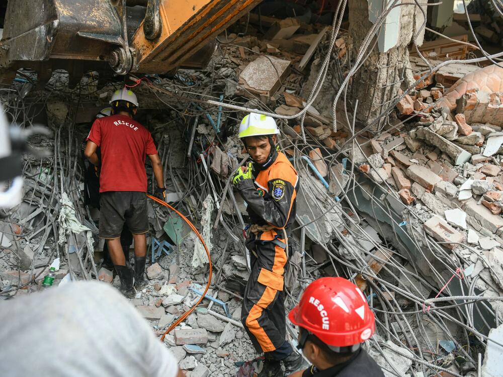 Rescuers search through the rubble of a damaged building looking for survivors in Mandalay on March 29, 2025.