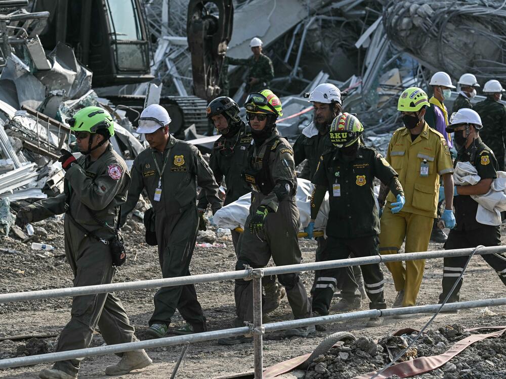 Rescue workers carry the body of a victim at the site of an under-construction building collapse in Bangkok on March 29, 2025.