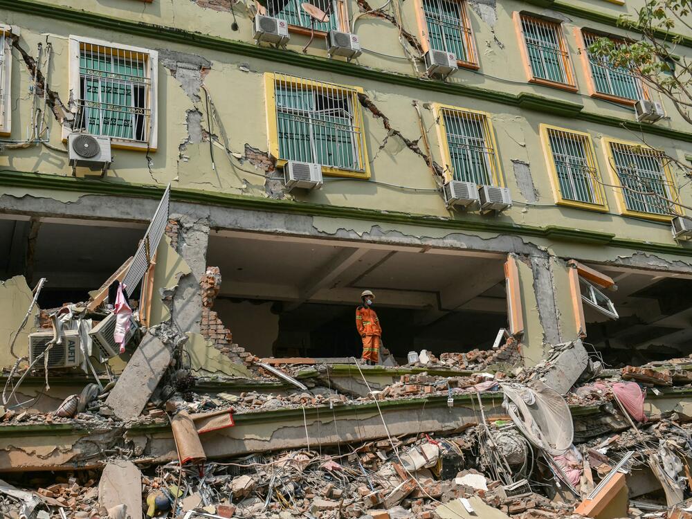 A rescue worker looks out over the rubble as teams attempt to free trapped residents at the destroyed Sky Villa Condominium development in Mandalay on March 29, 2025