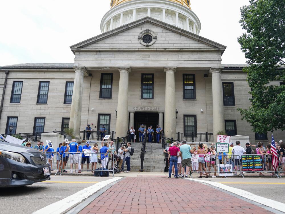 Karen Read supporters and counter-protestors, in pink and blue respectively, gather outside her July hearing at Norfolk Superior Court.