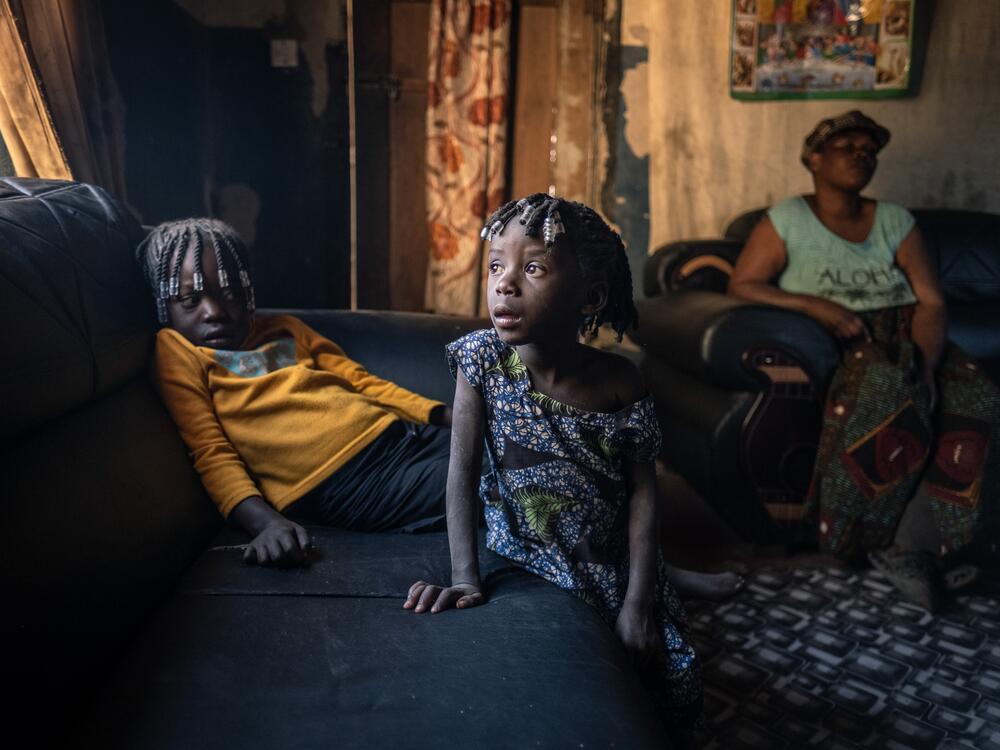 Winfrida Besa, 7 (center), with her 5-year-old cousin Mable, in their home in the lead-contaminated neighborhood of Magandanyama in Kabwe, Zambia. Winfrida has suffered from extreme lead poisoning that has left her severely stunted and with cognitive impairments that prevent her from understanding simple instructions. She is unable to attend school. Her cousin Mable has also tested positive for lead poisoning and is now on medication. Studies have found that the overwhelming majority of children living nea…