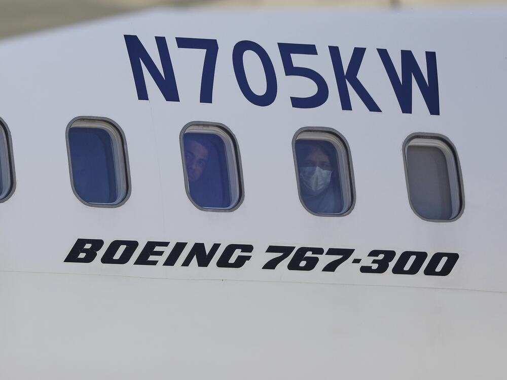 Venezuelan migrants deported from the United States peer through windows of an Eastern Airlines plane upon arriving at Simon Bolivar International Airport in Maiquetia, Venezuela, on Sunday, March 30, 2025.