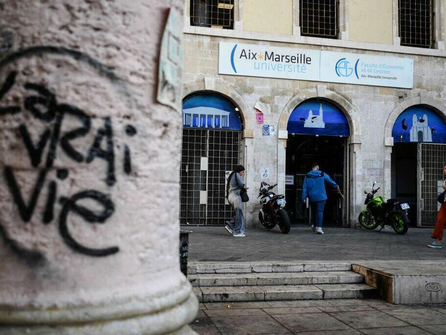 People walk past the faculty of economy of the Aix-Marseille University in Marseille on Oct. 4, 2023.