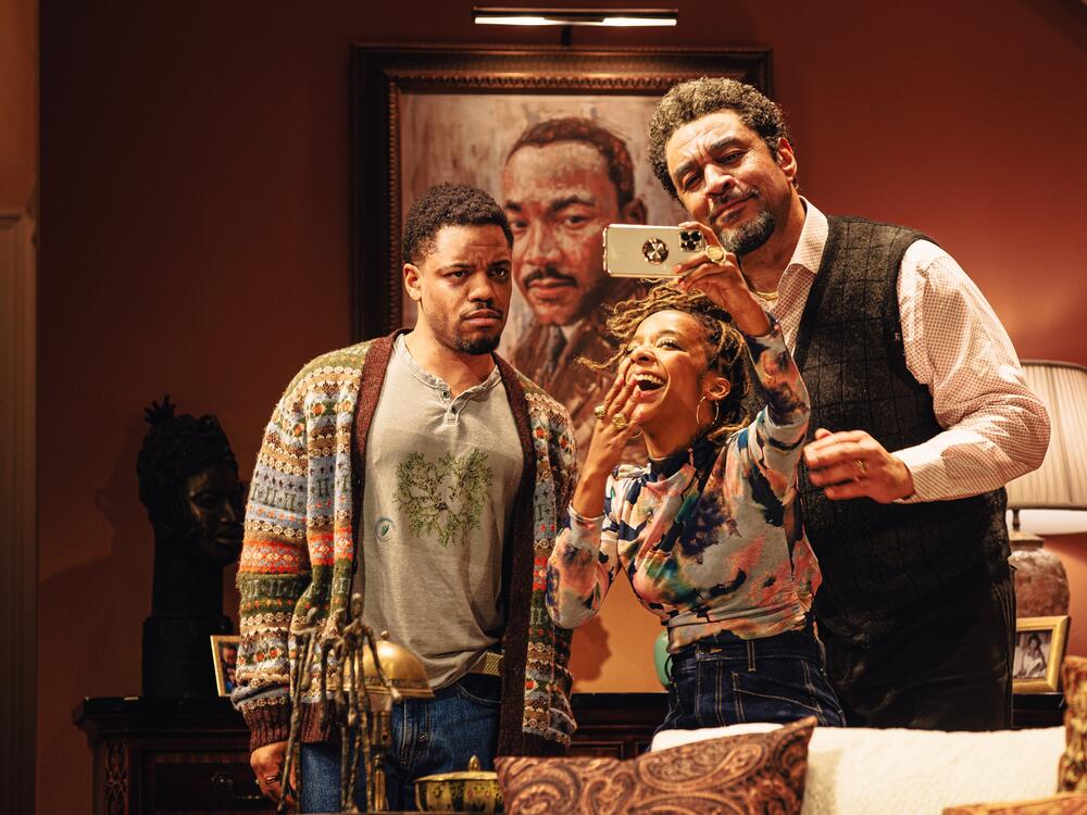 Left to right: Jon Michael Hill (Naz), Kara Young (Aziza) and Harry Lennix (Solomon) appear in an early, happier scene of the play <em>Purpose</em> after Aziza has just realized her friend Naz comes from a storied family with a role in the civil rights movement.