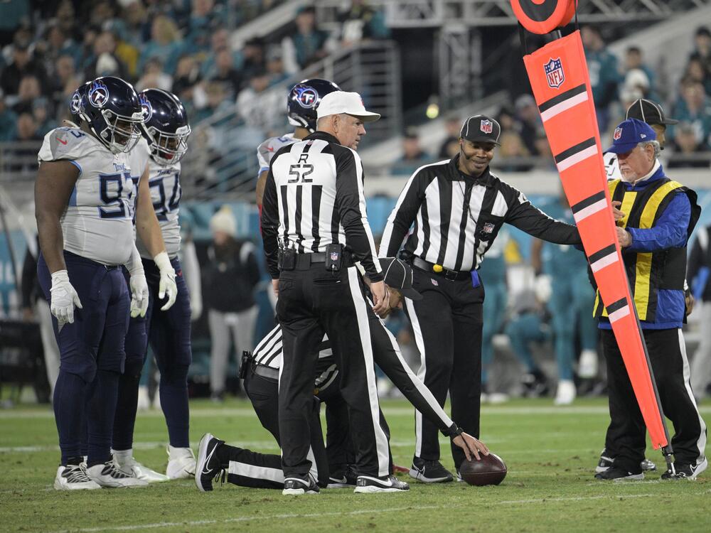 Referee Bill Vinovich (52) watches as the officiating crew takes a measurement during the second half of an NFL football game between the Jacksonville Jaguars and the Tennessee Titans in 2023. Starting next season, the NFL will move to a camera system to determine if a first down has been reached.