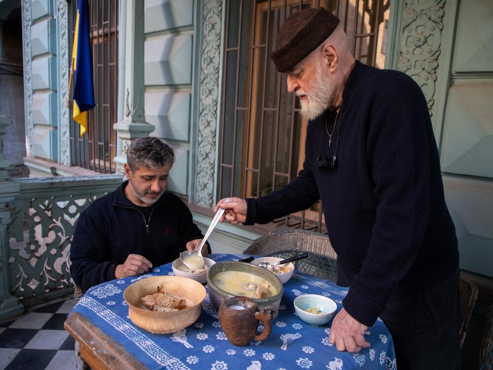 David Sulakauri, the photographer's father, serves the soup. An artist in Georgia, he also loves to cook. One of his favorite dishes is <em>khashi</em>, a soup believed to have healing powers.