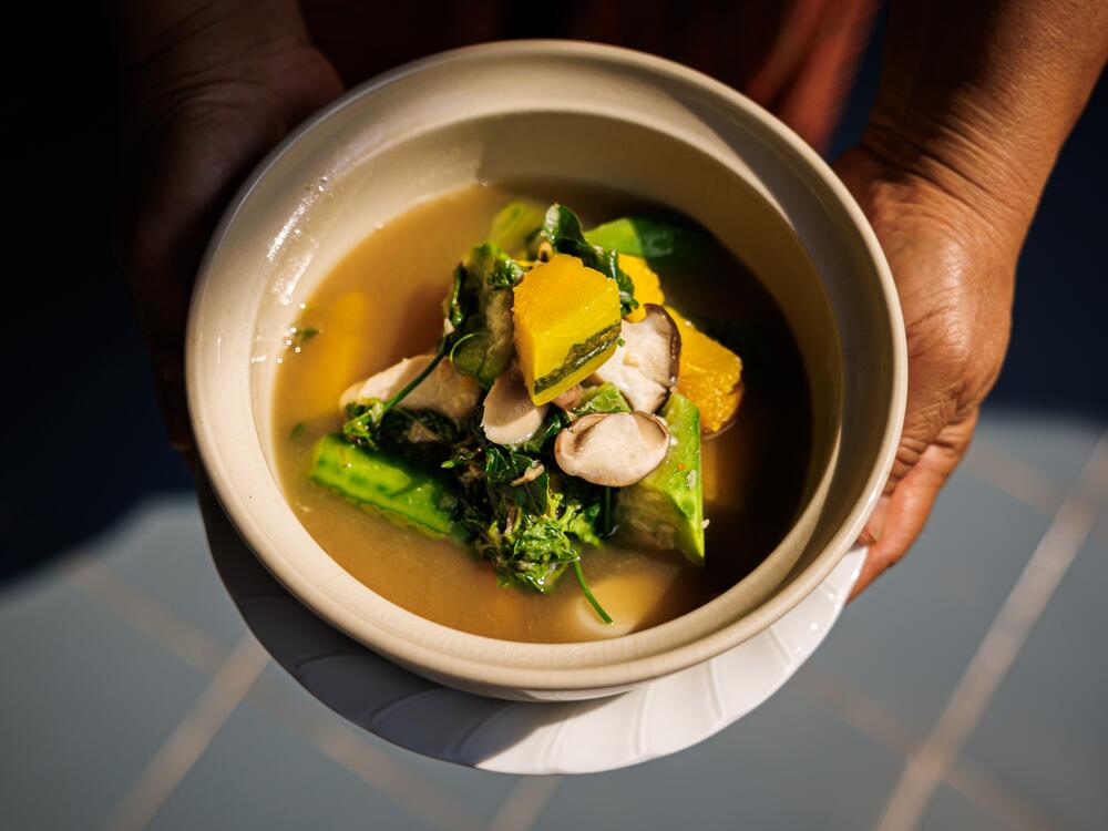 In Bangkok, Hnoi Lathitham, 57, holds a bowl of <em>gang liang</em> — a soup she ate weekly while growing up.