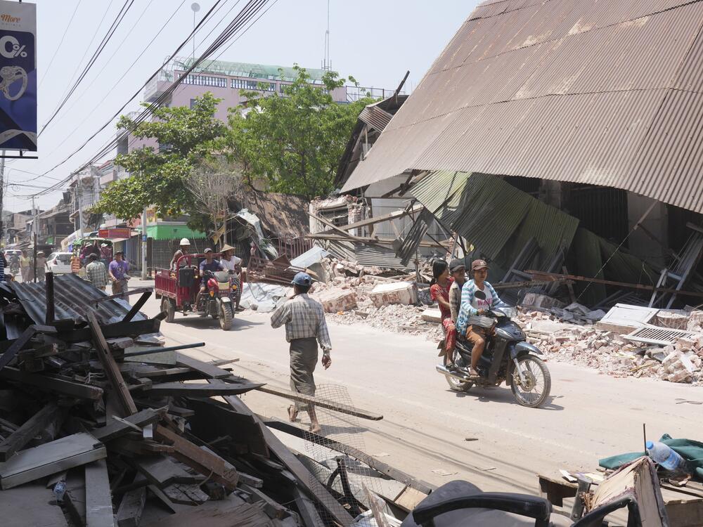 Local residents ride motorbikes near damaged buildings in the aftermath of Friday's earthquake, in Naypyitaw, Myanmar on Wednesday.