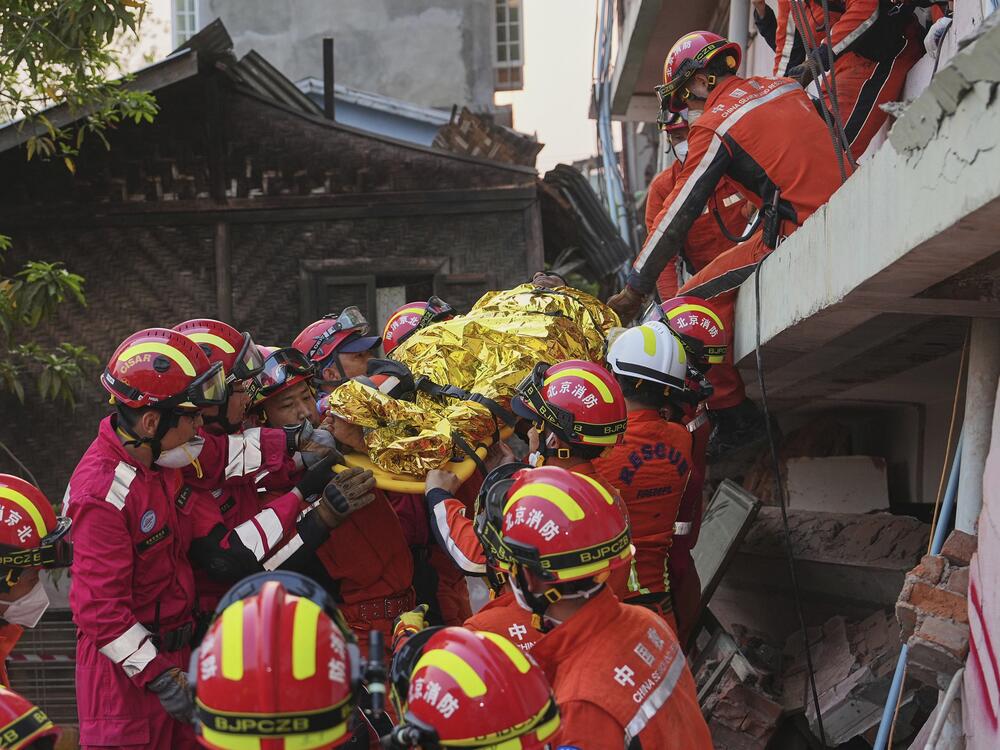 In this photo released by Xinhua News Agency, Chinese rescuers move a survivor out from a collapsed building in the aftermath of an earthquake in Mandalay, Myanmar on Wednesday.