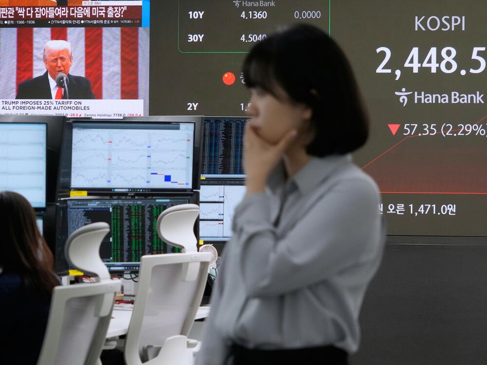 U.S. President Donald Trump is seen on a screen as a currency trader works at the foreign exchange dealing room of the KEB Hana Bank headquarters in Seoul, South Korea, Thursday, April 3, 2025.
