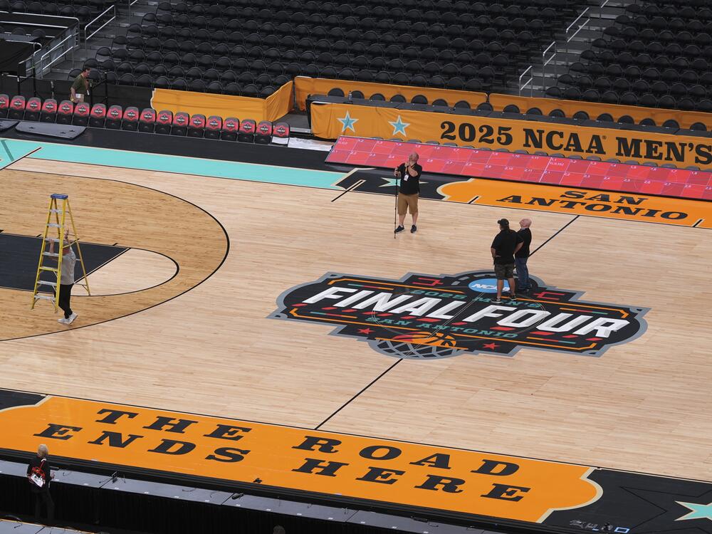 Workers make final preparations around the Men's NCAA Final Four college basketball court at the Alamodome, Monday in San Antonio. The men tip-off on Saturday. The Women's Final Four tournament, played in Atlanta, begins on Friday.
