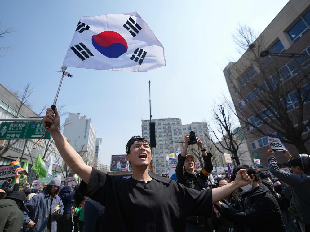 People react after hearing the news that President Yoon Suk Yeol was removed from office, in Seoul, South Korea, Friday, April 4, 2025.