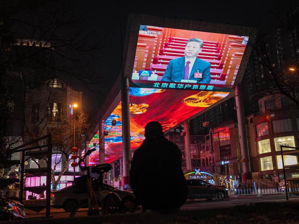 A news report of Xi Jinping, China's president, at the National People's Congress is displayed on a screen in Beijing on March 5. China set a forceful economic growth goal at about 5% for 2025, raising expectations for officials to unleash more stimulus later this year as they confront a trade war with Donald Trump.