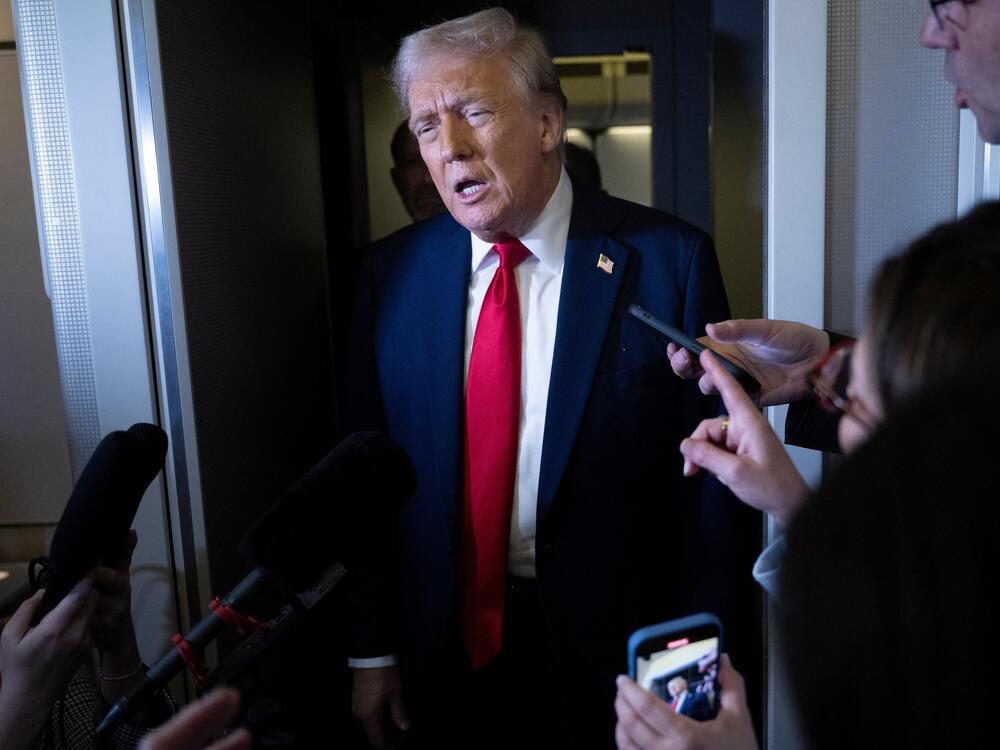 President Trump speaks to members of the press aboard Air Force One on Sunday.