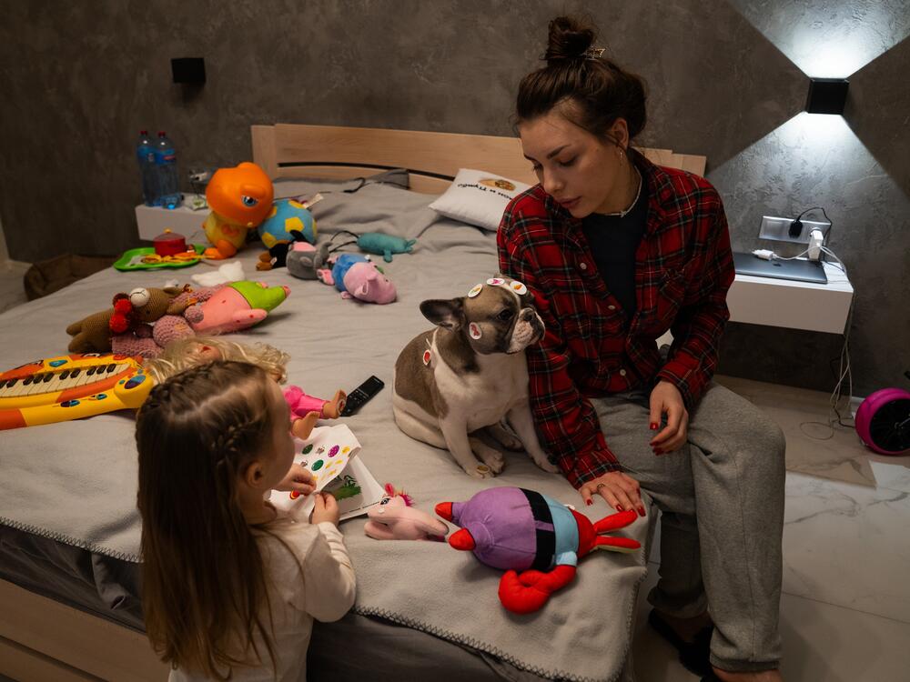 Hanna and her daughter Leya with their dog, Mia. Hanna says their dog shows the most fear — shaking and sometimes urinating on the floor — when they hear explosions outside.