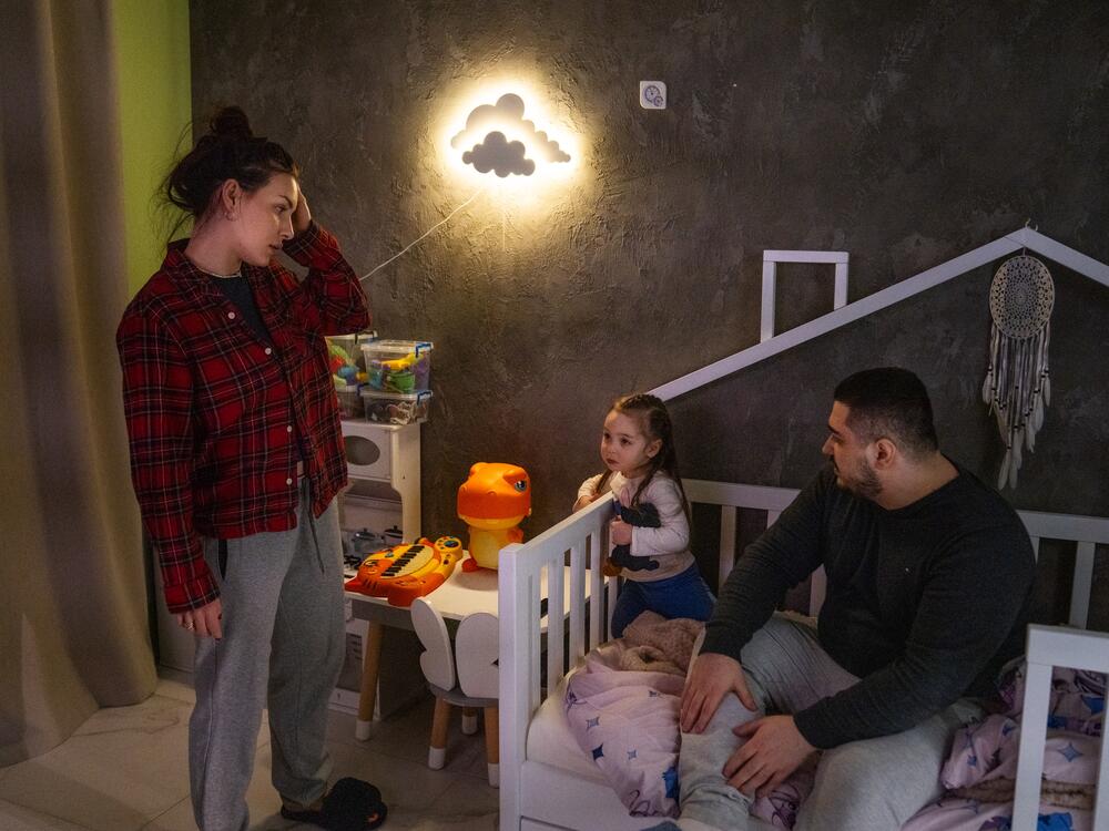 Hanna and Arkadii Rubin try to convince their daughter Leya, 2, to go to bed, although she doesn't want to. They live in an apartment in Kharkiv where, just over a year ago, part of the building was damaged in a missile attack.