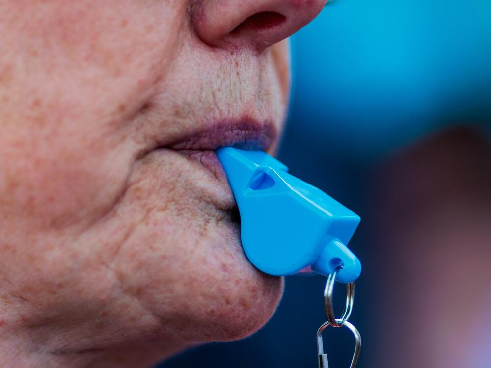 A person blows a whistle as they join others taking part in a protest of the Trump administration's policy on Saturday, April 5, 2025 in Richmond, Virginia.