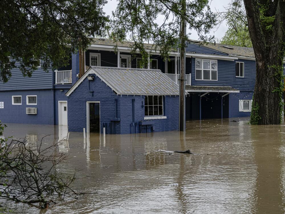 A flooded home is seen from the banks of the Ohio River on Saturday in Louisville, Ky.