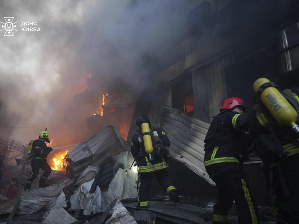 In this photo provided by the Ukrainian Emergency Service, emergency services personnel work to extinguish a fire following a Russian missile attack in Kyiv, Ukraine, Sunday, April 6, 2025.