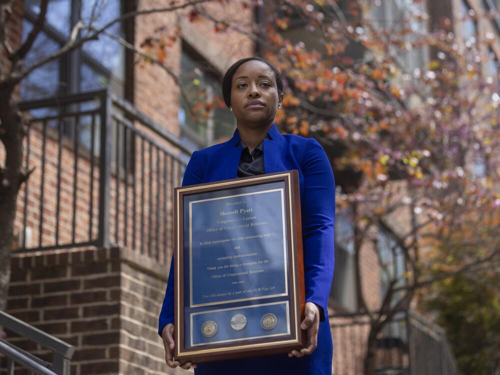 Sherrell Pyatt holds a commissioner's award she received for work she did at Customs and Border Protection examining in-custody deaths.