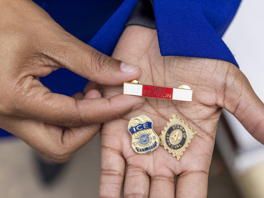 Sherrell Pyatt holds pins she received while working for the Department of Homeland Security, the United States Postal Service and Immigration and Customs Enforcement.