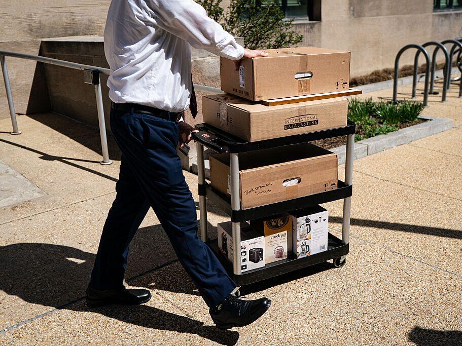 A worker wheels out the belongings of a fellow employee who was dismissed, outside of the Mary E. Switzer Federal Office Building, which houses HHS offices in Washington, D.C., on Tuesday.