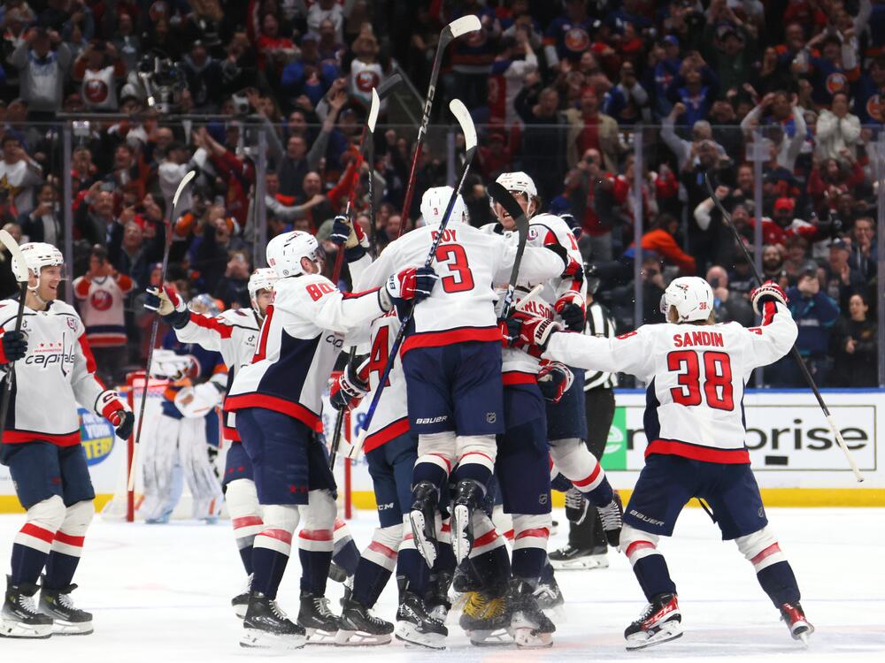 Alex Ovechkin #8 of the Washington Capitals celebrates with teammates after scoring his 895th career goal during the second period against the New York Islanders to become the NHL all-time goals leader on Sunday in Elmont, New York.