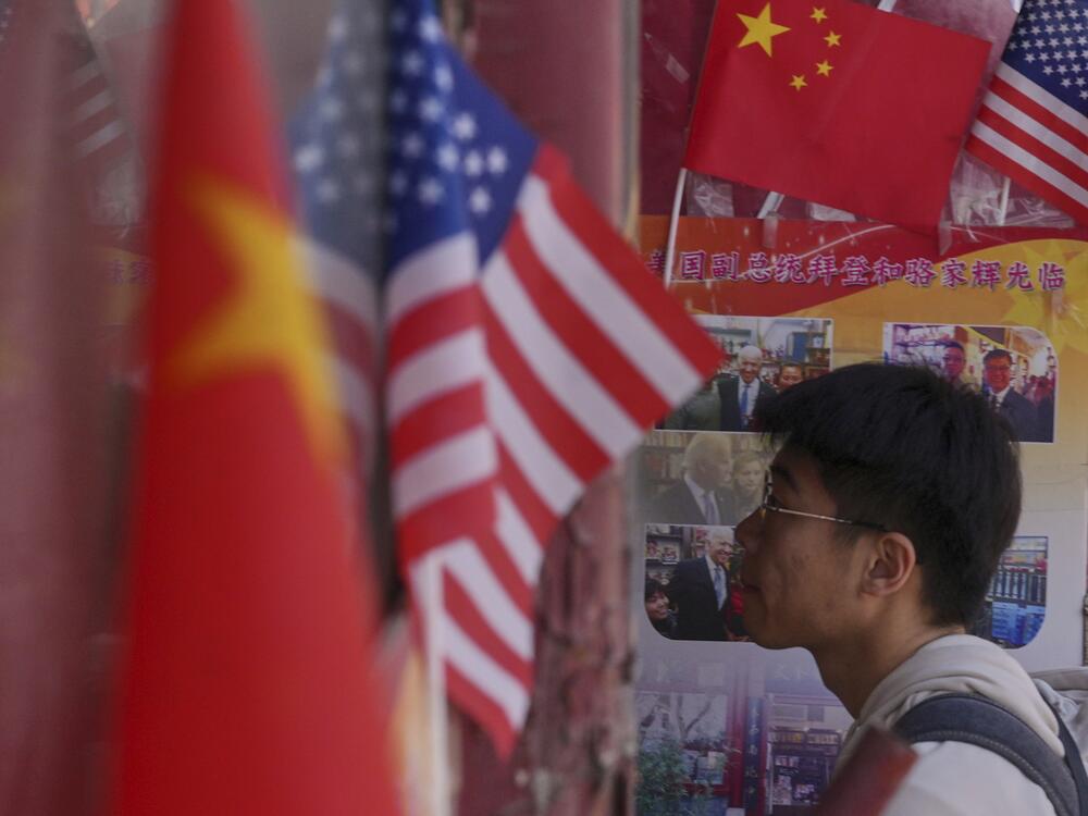 A man walks into a merchandise store displaying Chinese and United States' national flags, in Beijing on April 3.